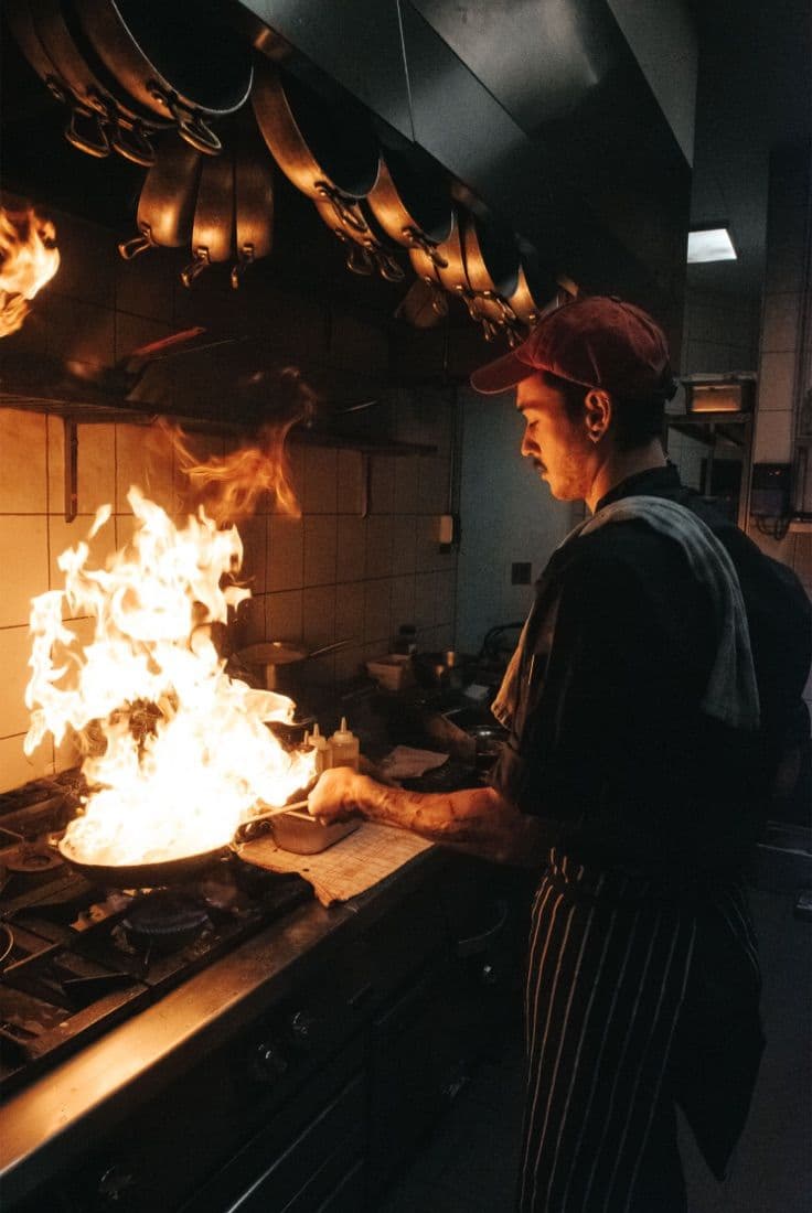 Le Conteur restaurant kitchen, chef flambéing a dish